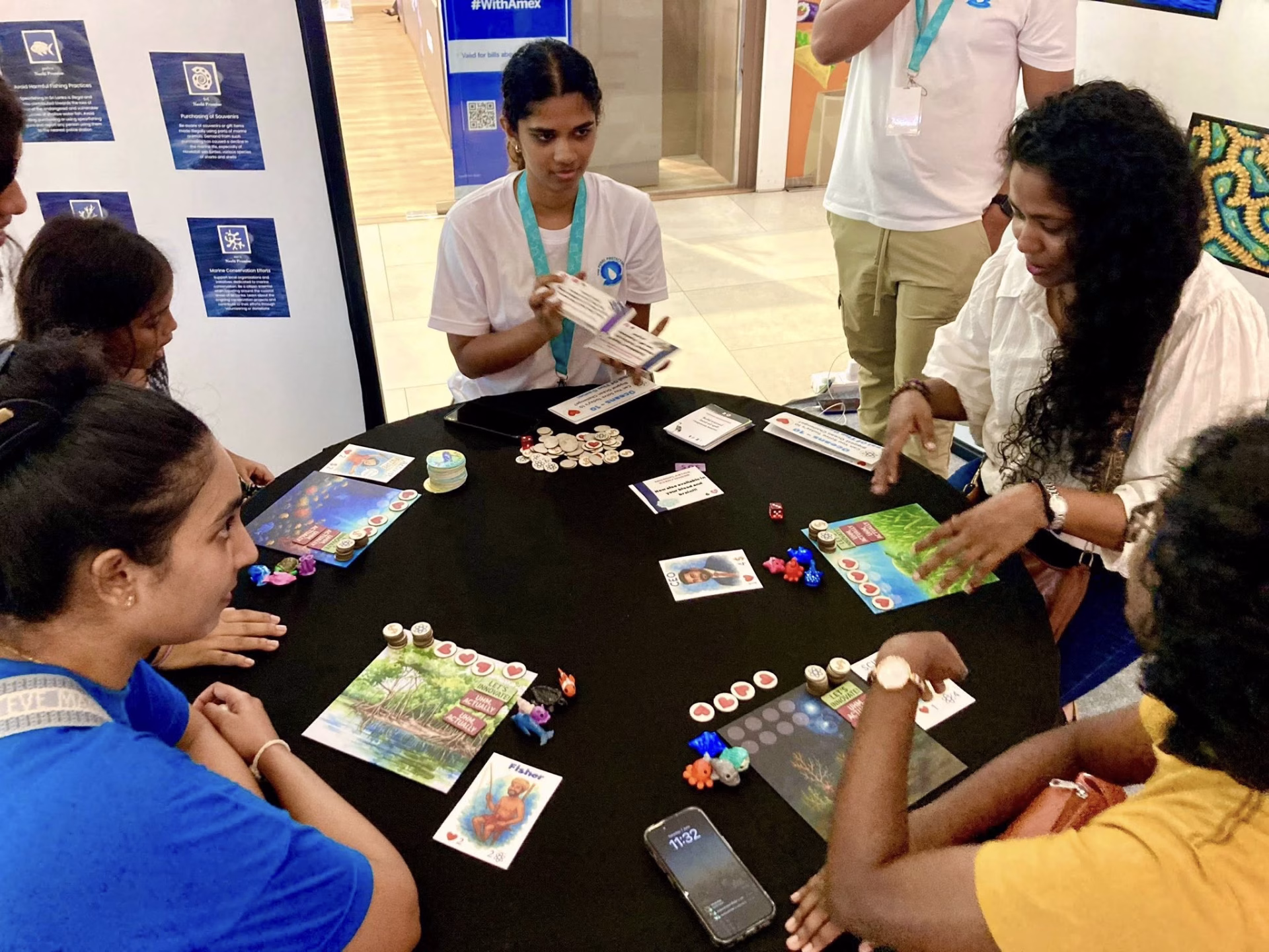 Participants playing an interactive educational board game focused on ocean conservation and marine ecosystems.