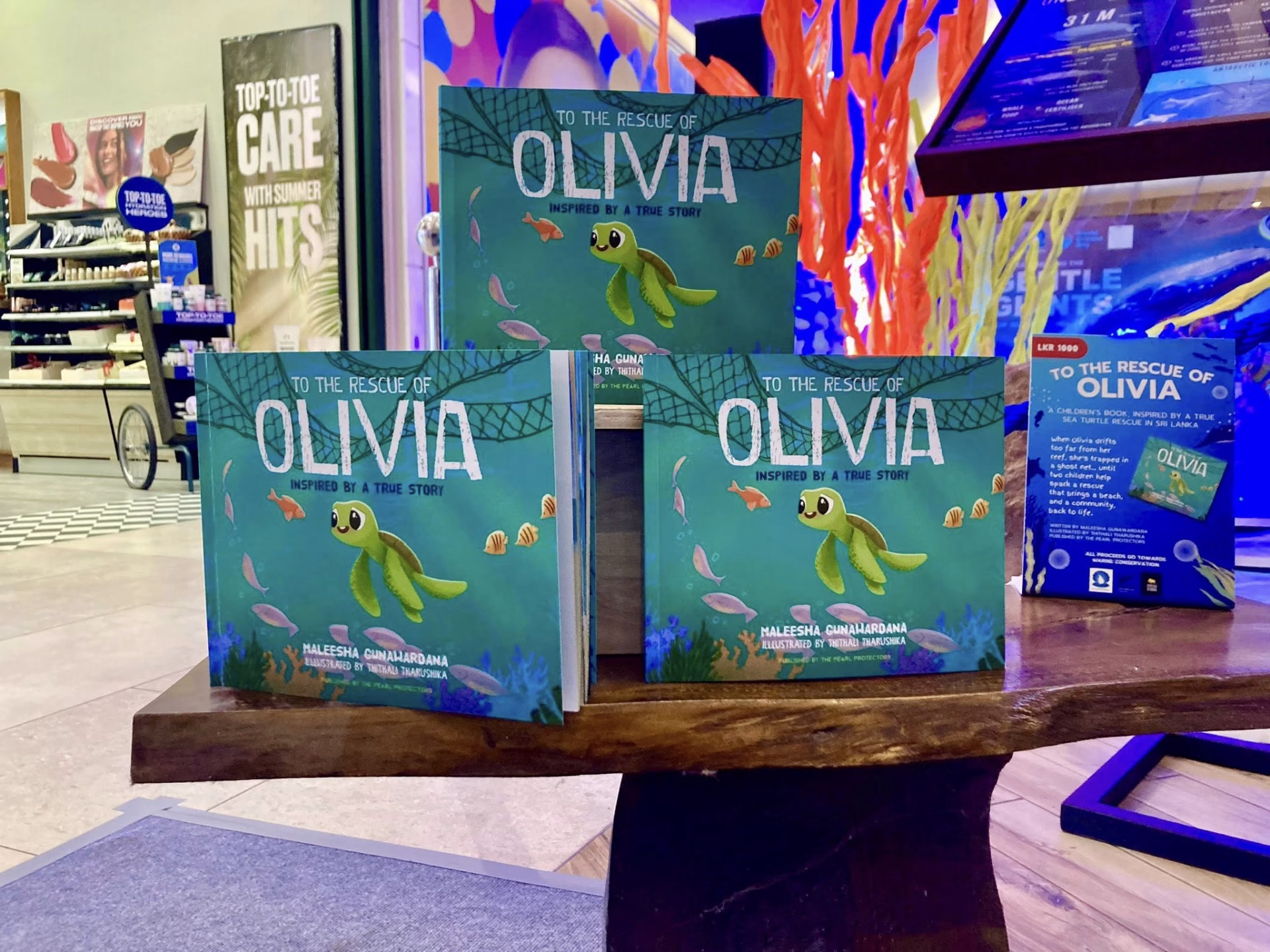 Display of the book “To The Rescue of Olivia” featuring a sea turtle character, promoting marine awareness and education for children.
