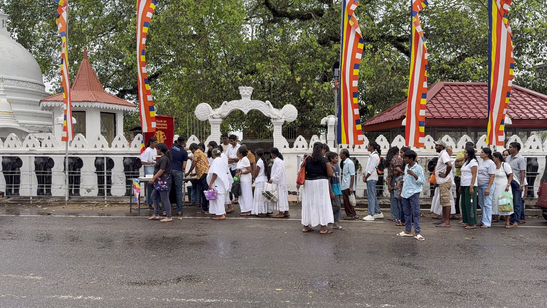 Devotees queuing for sisil pan at the Leo Club of Kolonnawa dansala near the temple during Poson Poya Day.