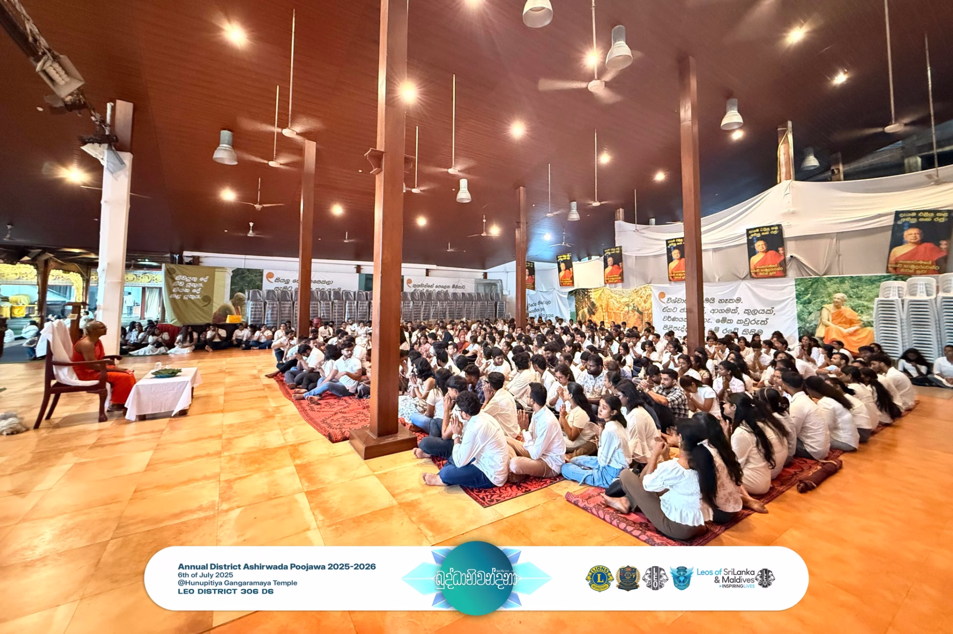 A Buddhist monk leading blessings as Leos sit in reverence during Buddhabhiwandana 2025 at Gangaramaya Temple, Colombo.