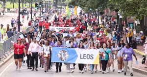 Young Leos marching with the official Leo Club banner during the Lions International Convention parade
